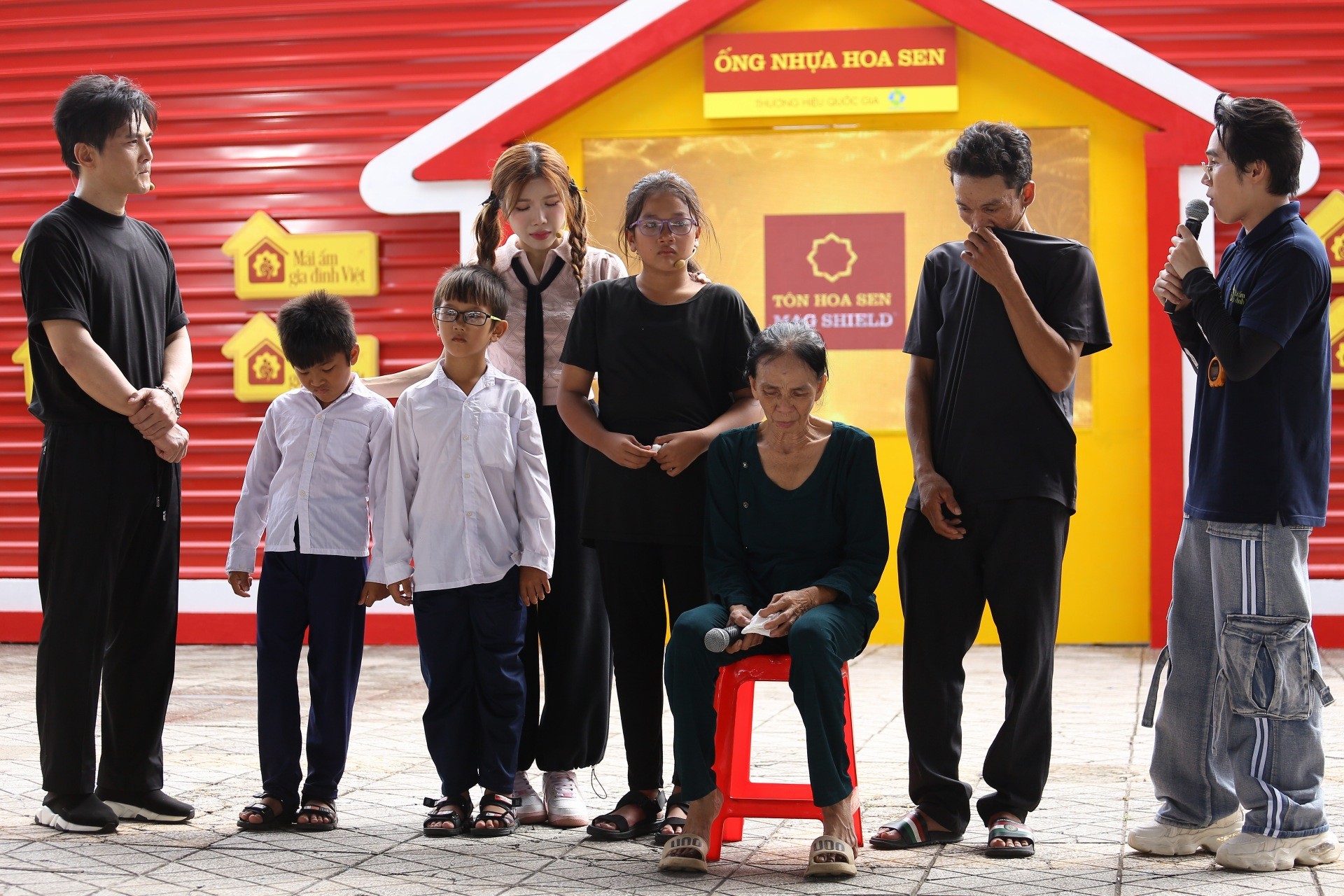 Ca sĩ Lâm Hùng cùng các nghệ sĩ đứng dưới mưa ghi hình cho 'Mái ấm gia đình Việt', miễn giúp các em nhỏ được hạnh phúc